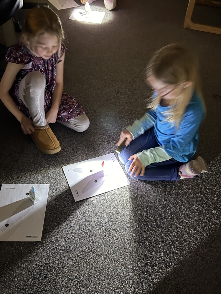 First graders using flashlights to learn about shadows. 