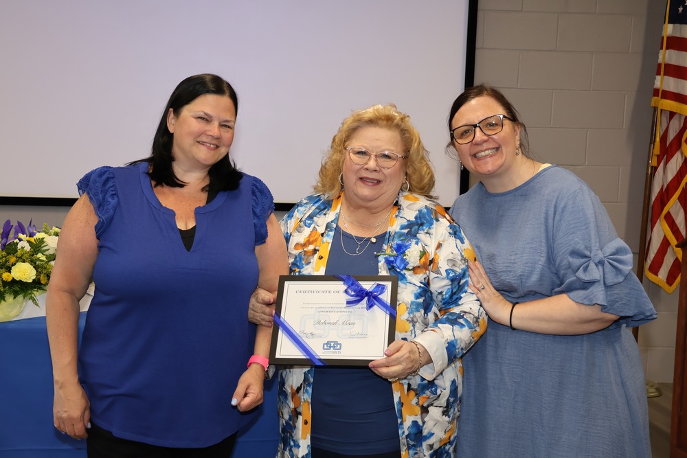two teachers alongside retiring colleague
