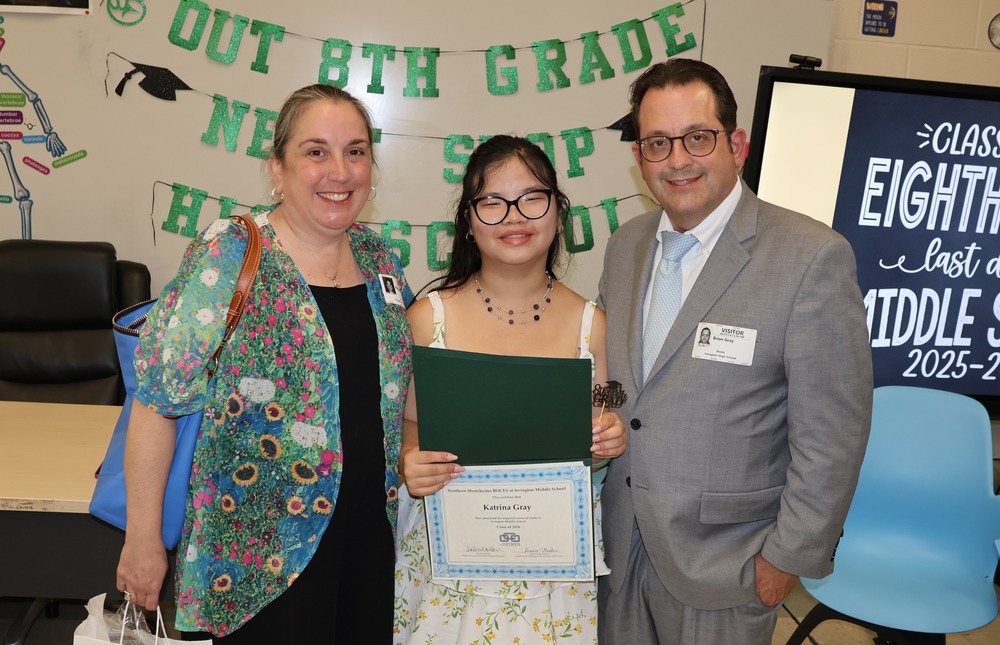 parents pose with 8th grade graduate