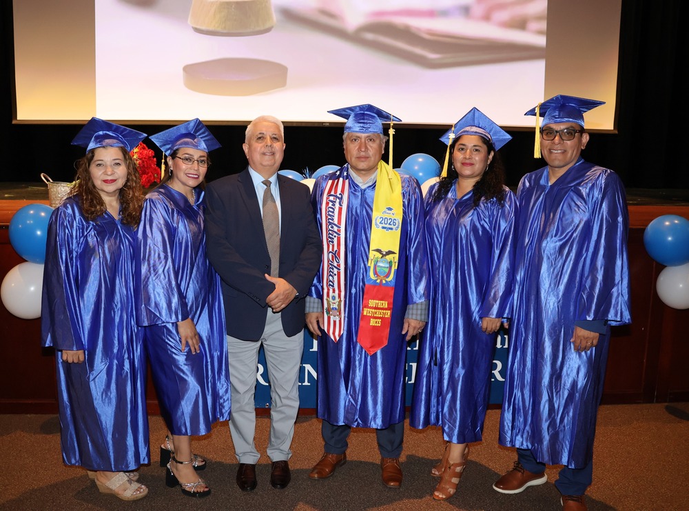 teacher is flanked by graduates at ceremony