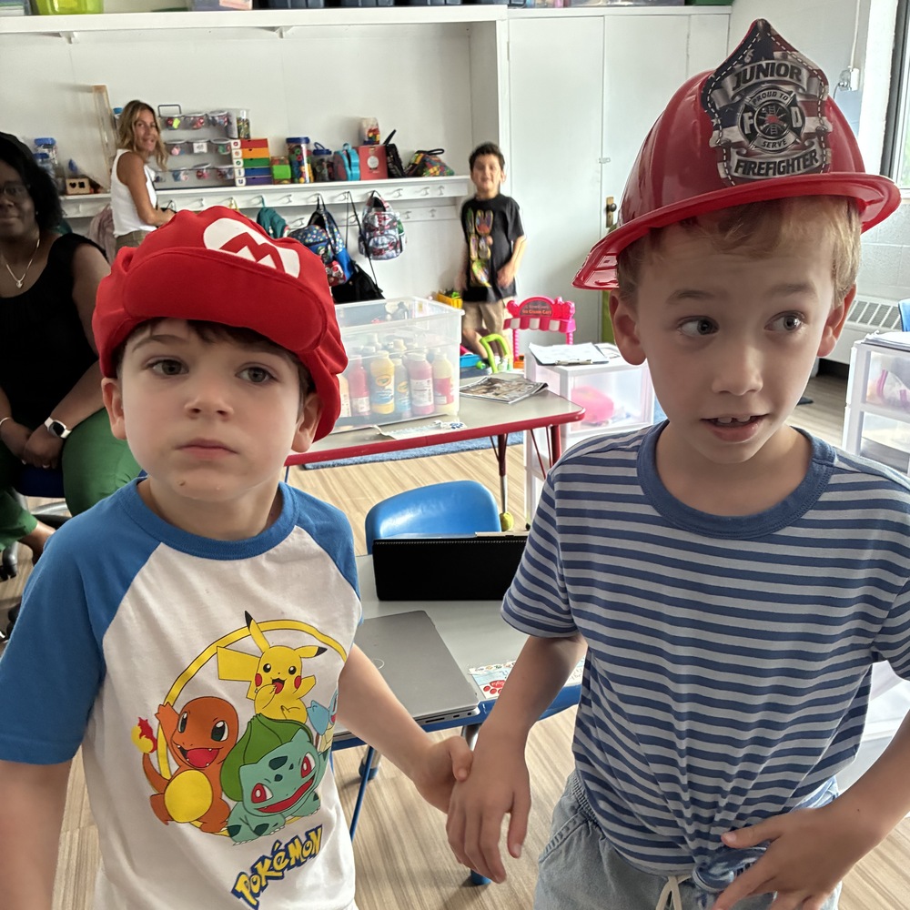 Two boys wearing a Mario Brothers hat and fireman's helmet for Crazy Hat Day.