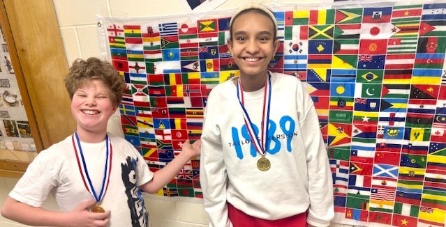 two students in front of flag mosaic