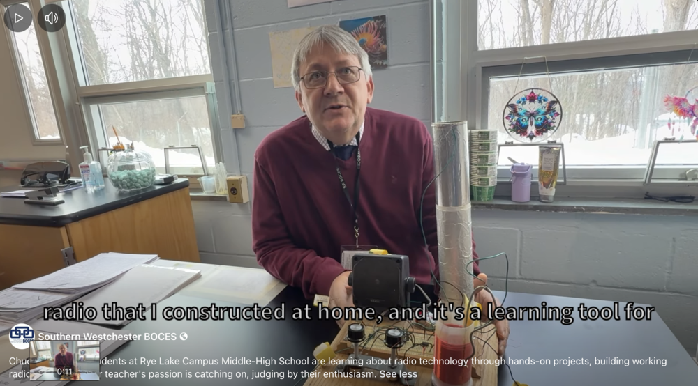 teacher demonstrates crystal radio he made