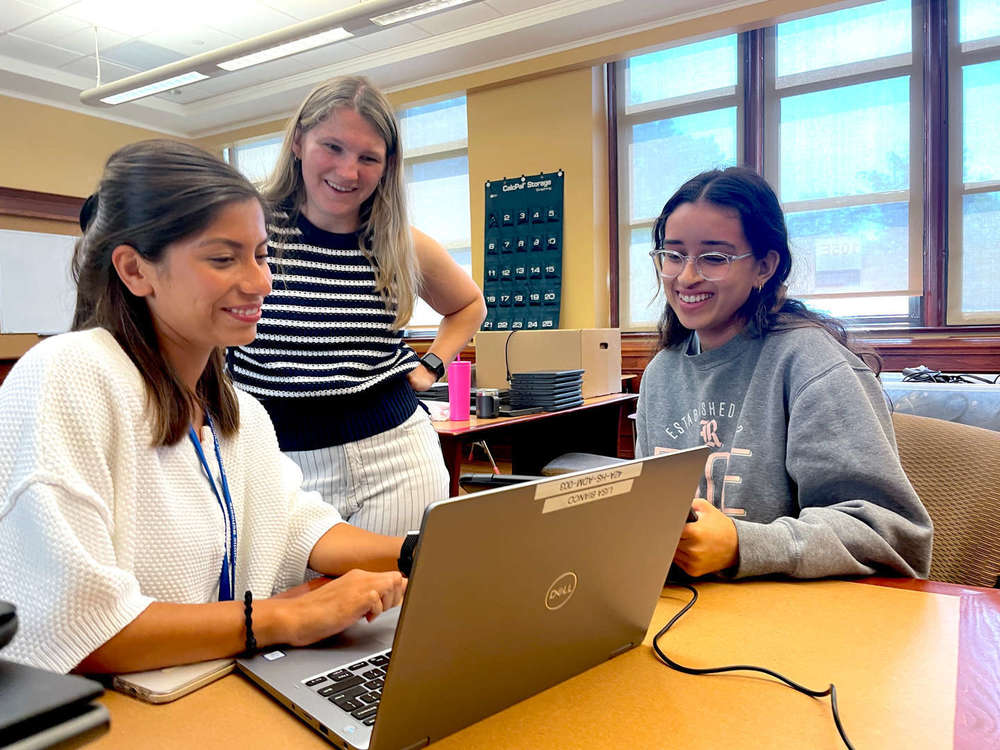 Three women looking at a laptop