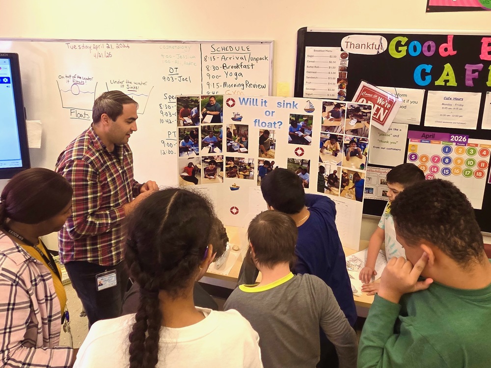 teacher shows students a science project