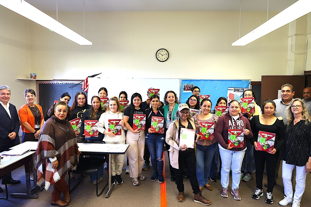 class photo with students holding up donated textbooks