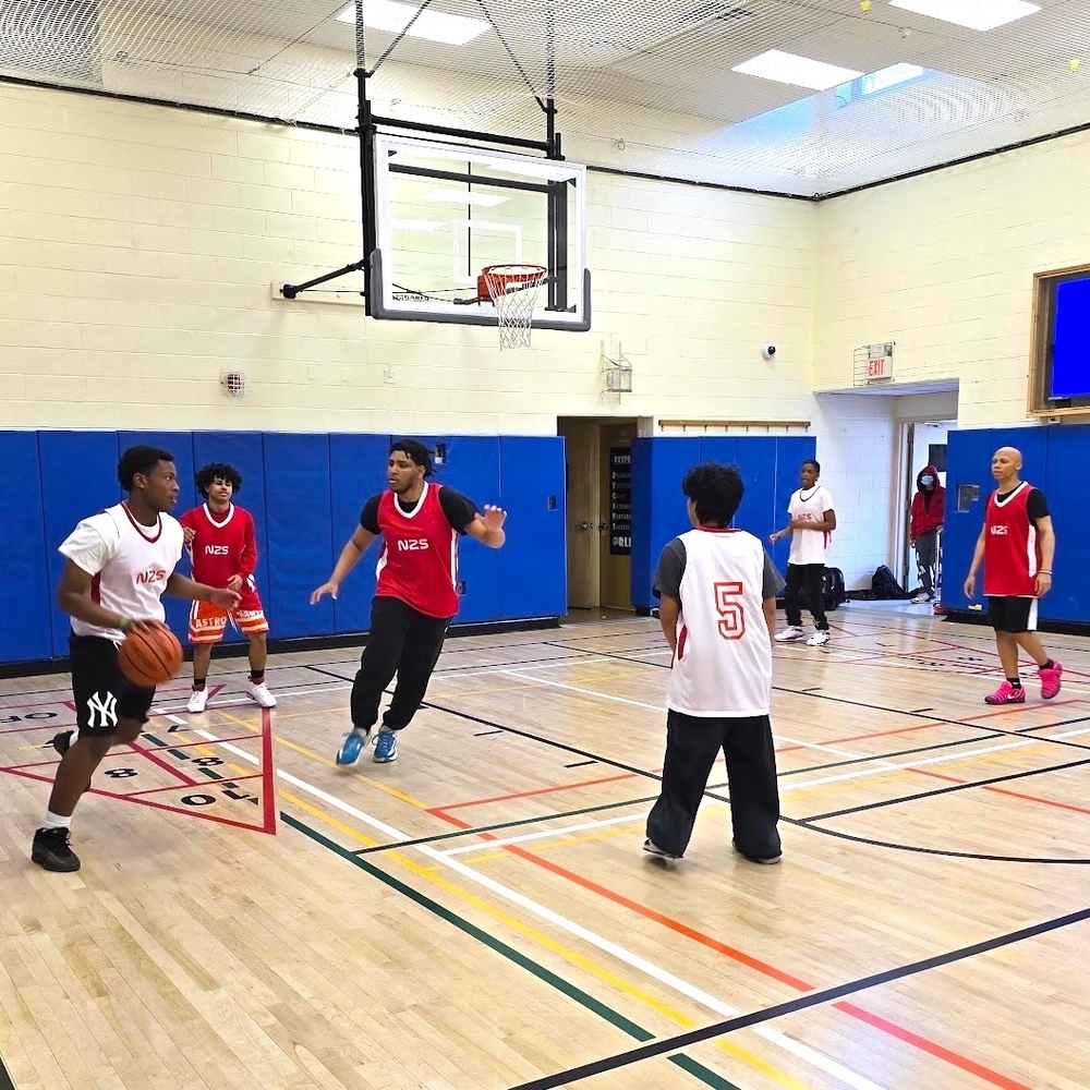 students play basketball in gymnasium