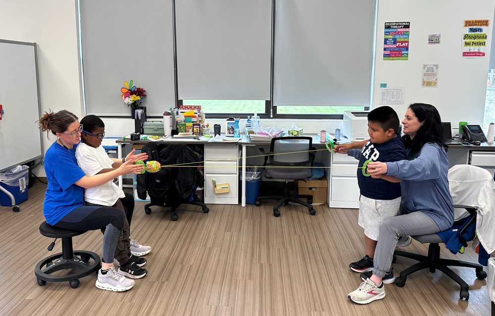 Teachers work with students using stretchy bands