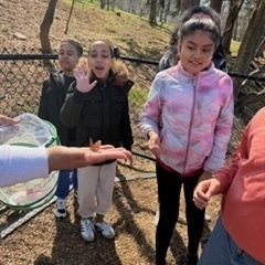three students viewing butterfly reliease