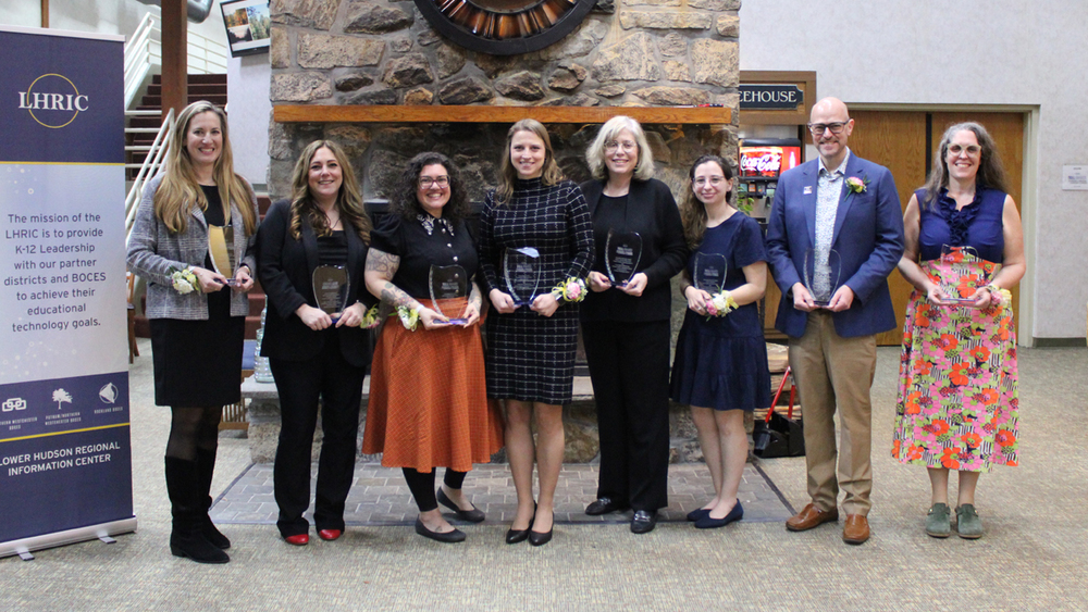 TELL Award Recipients 2026 standing in front of a fireplace holding their award