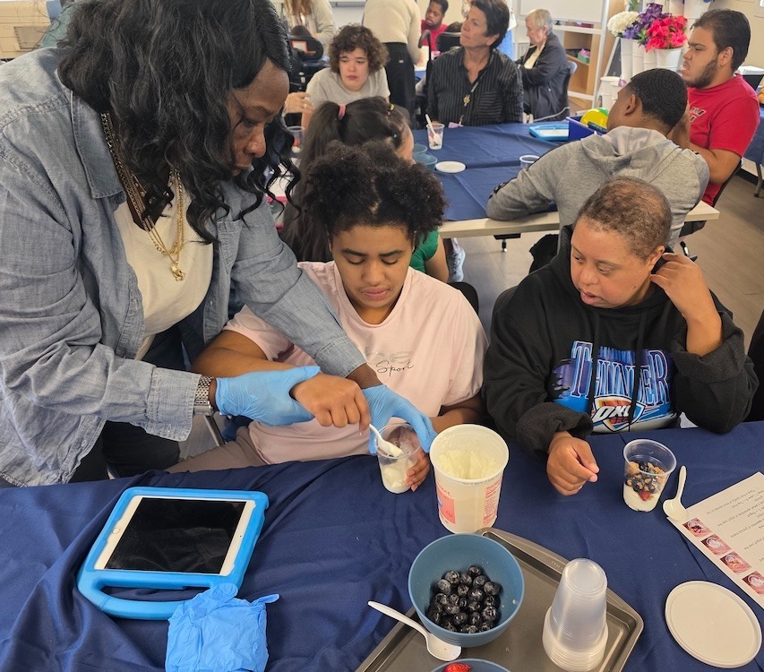 teacher assists two students at luncheon