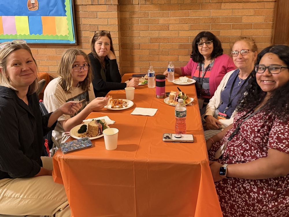 parents, student and teachers sit around a lunch table