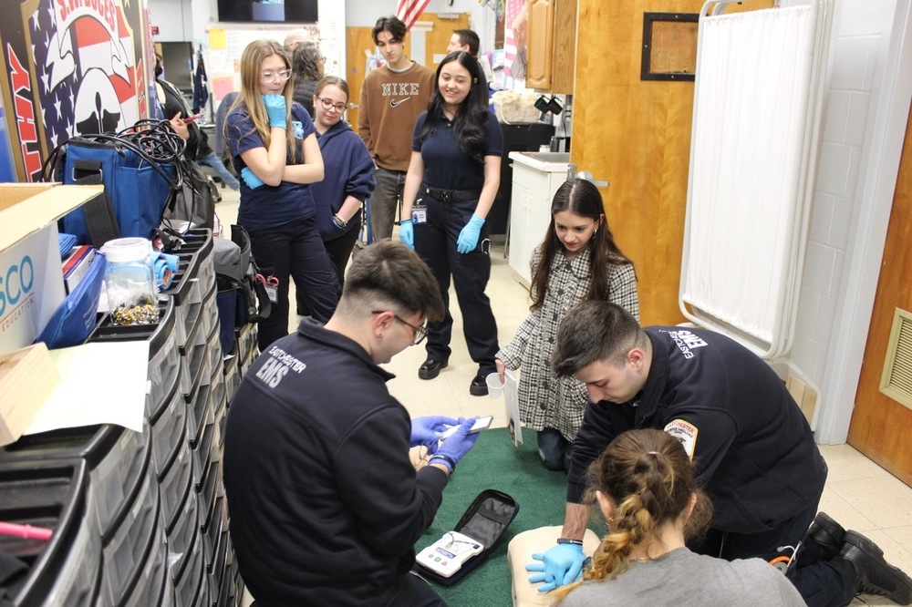 EMS students practice using an AED while parents tour the classroom.