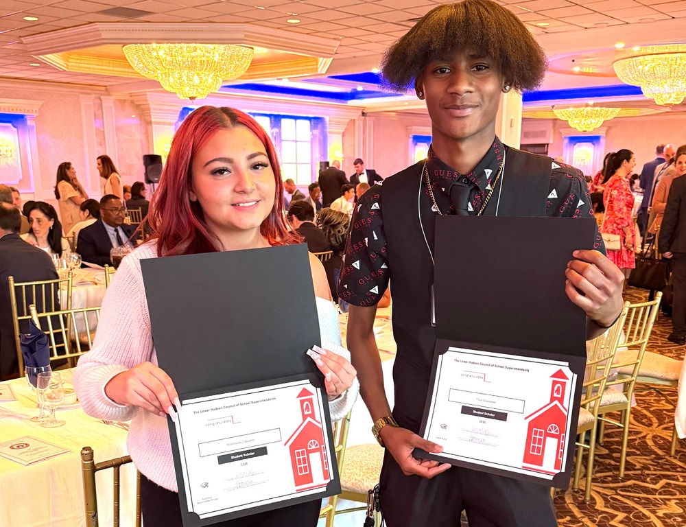 two students holding certificates