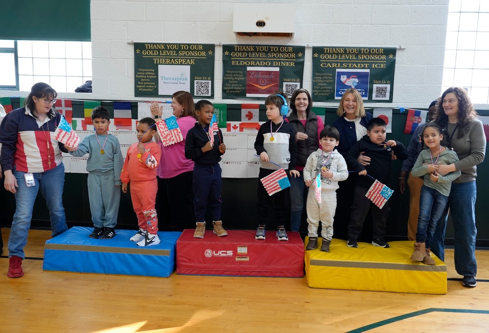 teachers and students stand on Olympic podium
