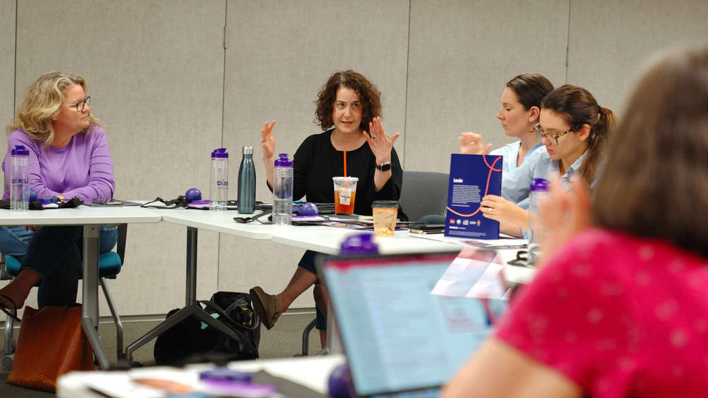 5 women sitting at tables