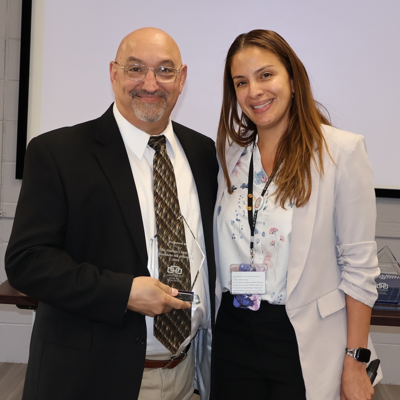 teacher and assistant principal pose with award