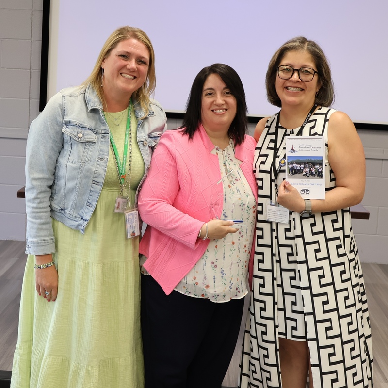 principal, counselor pose with college adminstrator holding award