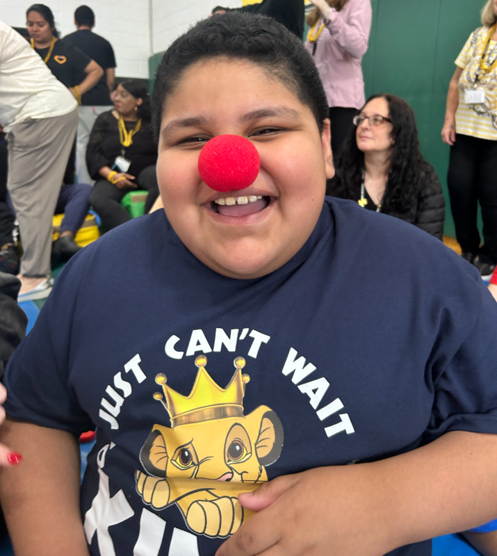 student with red nose smiles at performance