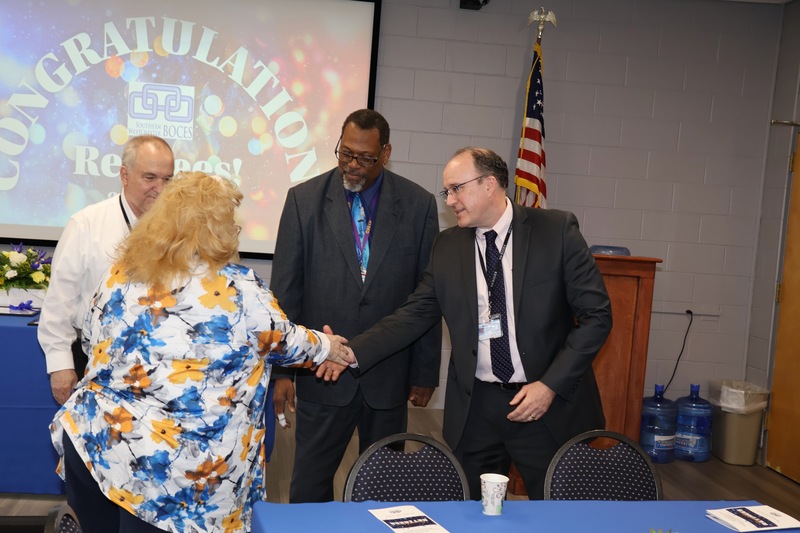 administrators congratulate retiree