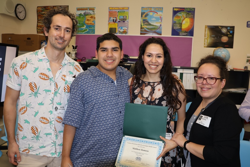 graduate poses with parents and grandma