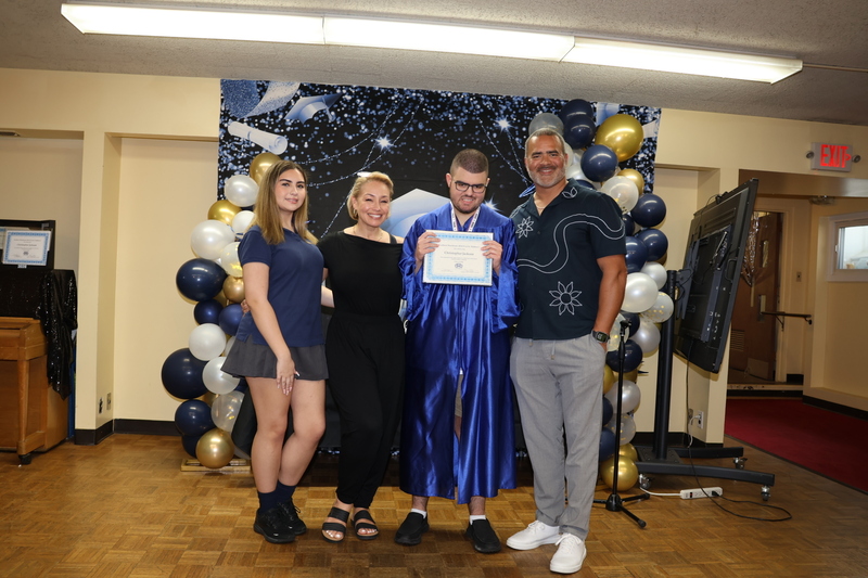 family poses on stage with graduate
