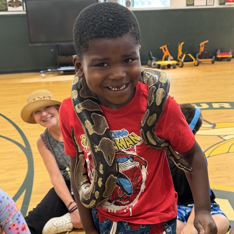 boy smiles with snake around his body