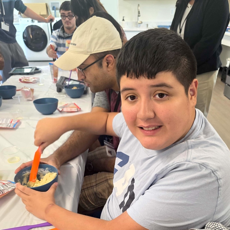 student smiles during baking activity