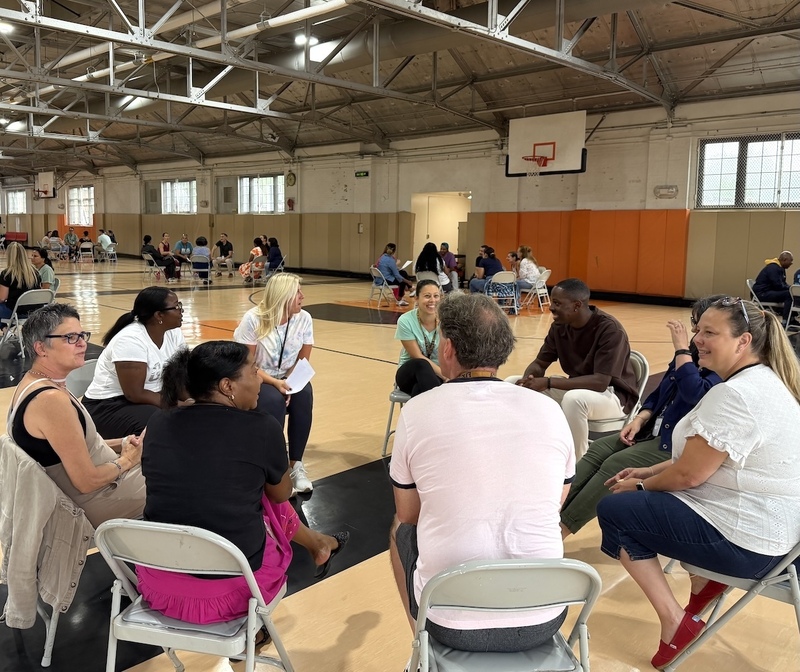 teachers in a circle in a gym