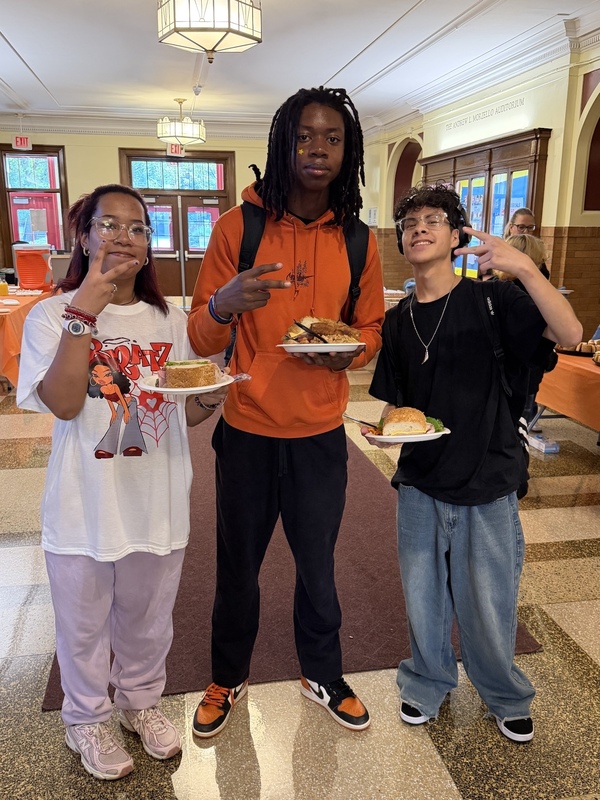 three students smiling at lunch time