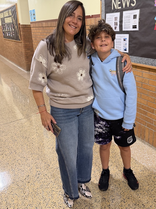 parent and teacher smile in hallway