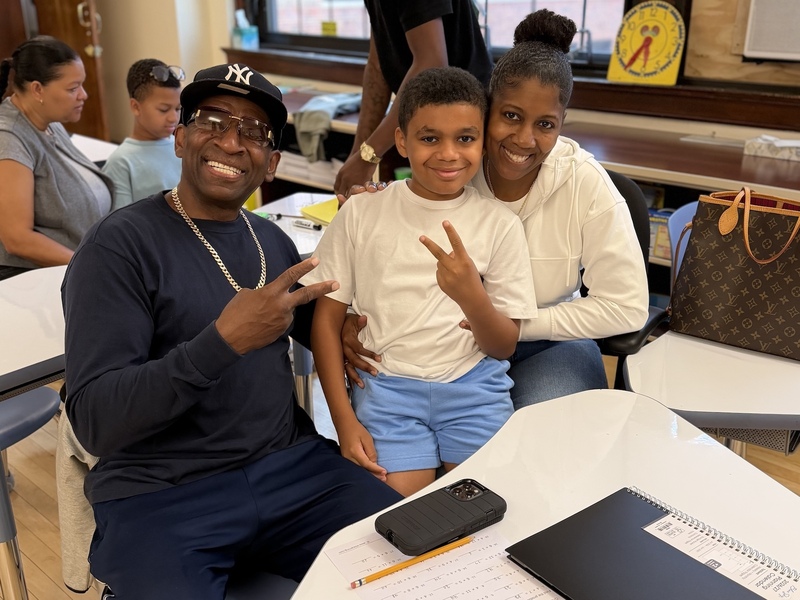 parents smile with son in classroom