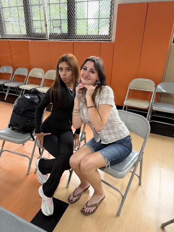 two students in folding chairs smilin