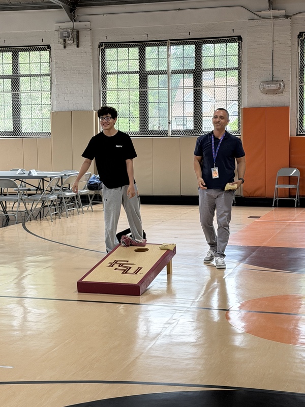 student and teacher playing cornhole