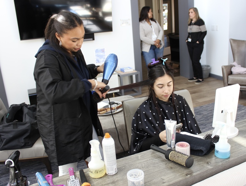 A Cosmetology student dries a client's hair at the Ronald McDonald House in Valhalla.
