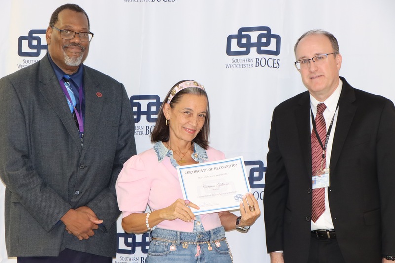 teacher holds certificate alongside administrators