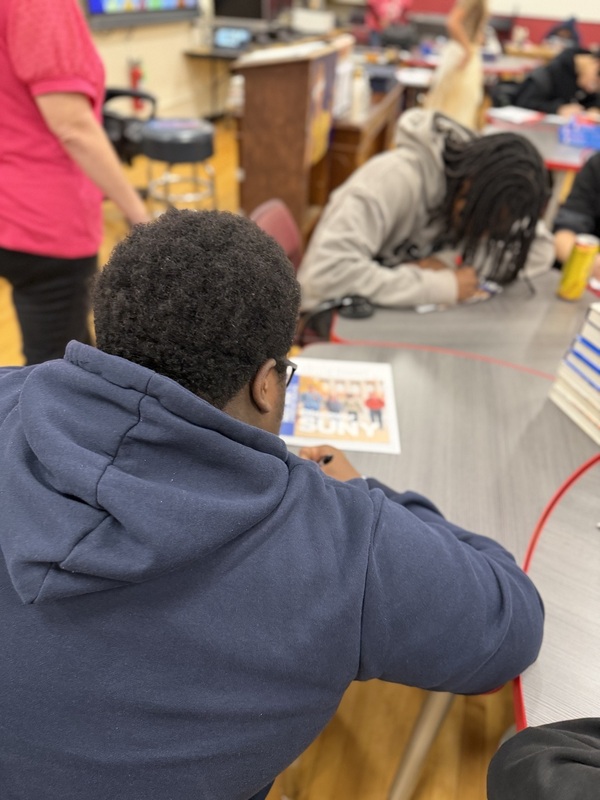 students at table work on college materials