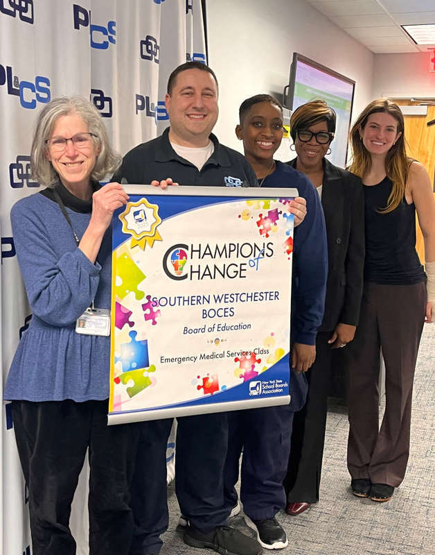 board members and faculty honorees hold banner