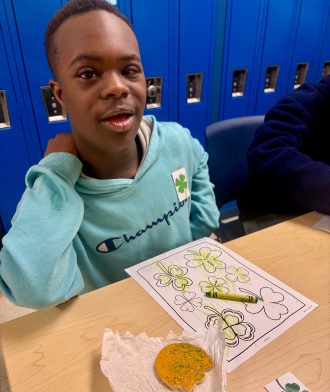 student shows off his cookie and crafts