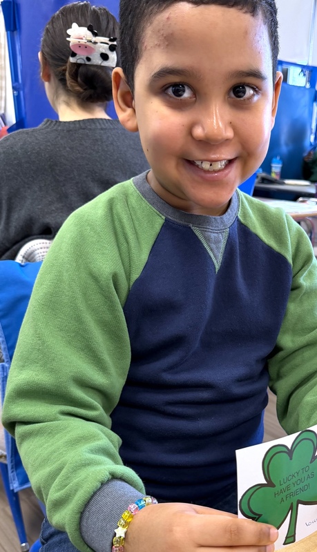 boy smiles proudly after completing shamrock project