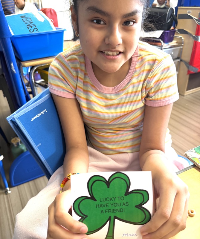 girl shows off her shamrock designed craft