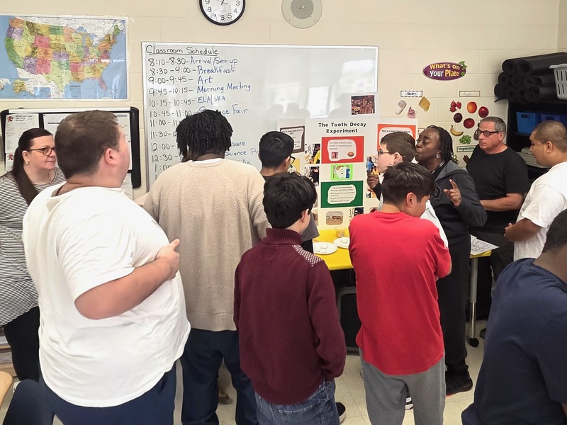 teacher shows off science project to class