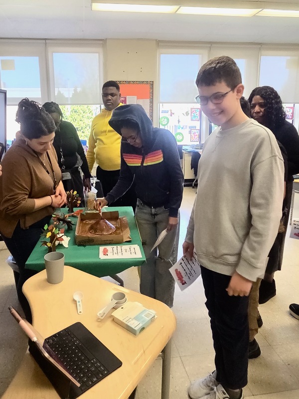 student looks on as teacher explains volcano project