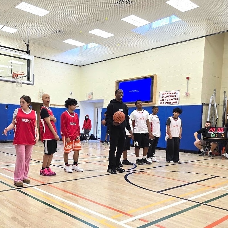 players and educator line up at half-court