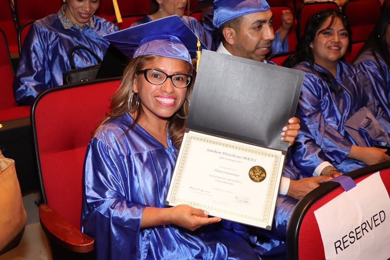 GED graduate holding her diploma