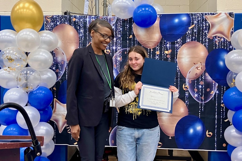 principal and student holding certificate