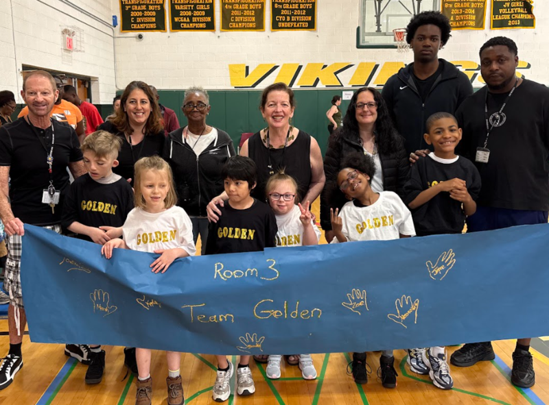 teachers and students in black holding a Room 3 banner