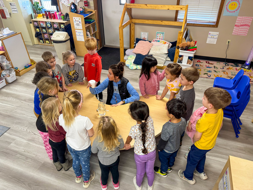Teacher surrounded by class or preschoolers