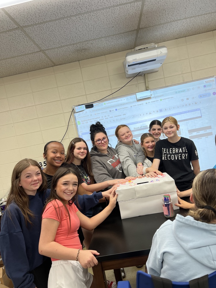 group of students hands on prayer box