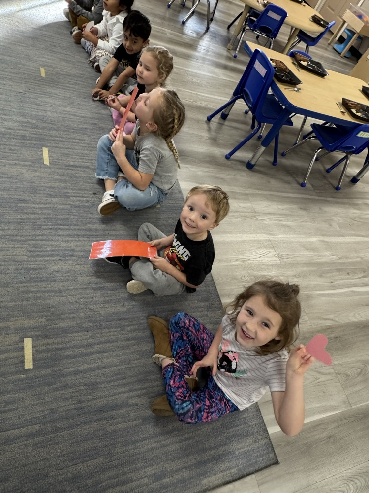 children holding up paper body parts and smiling